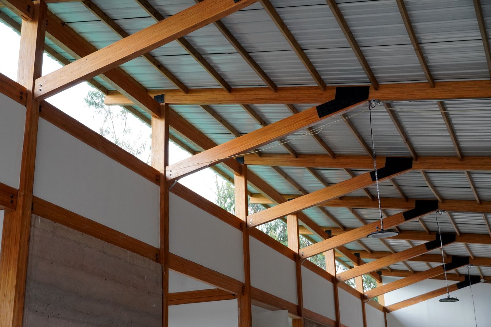 Estructura de cubierta en madera laminada con tejado metálico, vista interior del campus